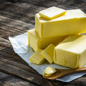 Butter blocks and pieces on wooden table. Copy space manteuilla alpina
